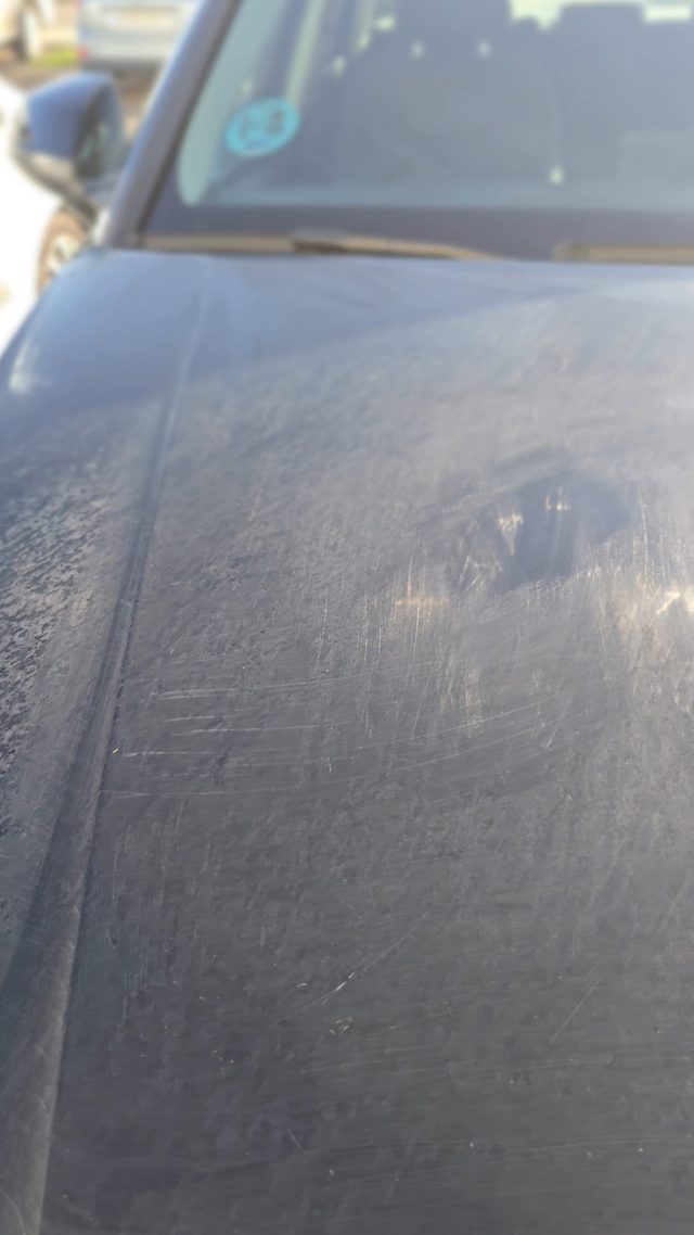 Close-up of sun-damaged black paint, dull and scratched