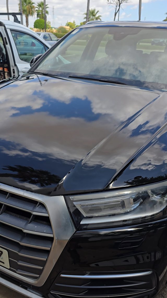 The same Audi bonnet after restoration, reflecting the clouds