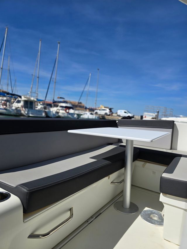 Clean cockpit seating and table on a motor boat in a Mar Menor marina