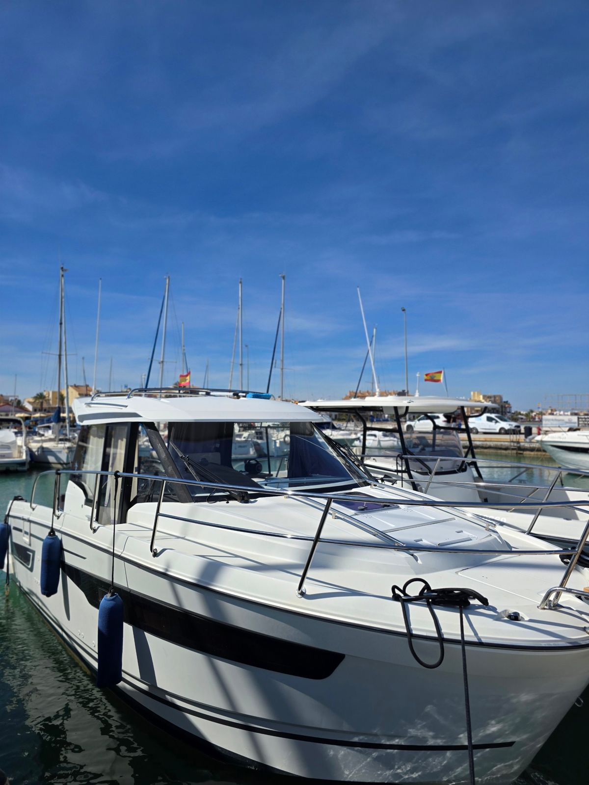 A freshly cleaned white motor boat at its berth in a Mar Menor marina