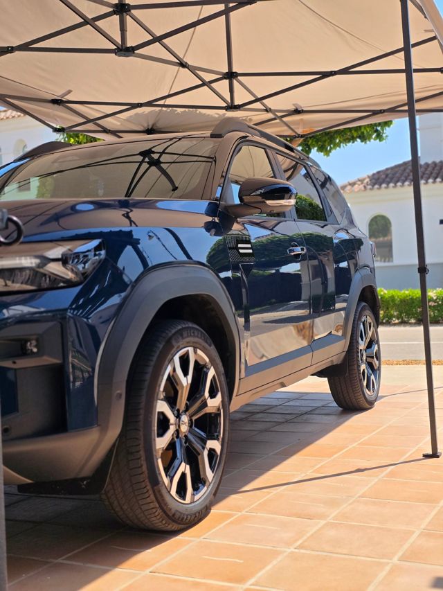 A freshly finished dark blue Dacia Duster under the gazebo on a villa driveway
