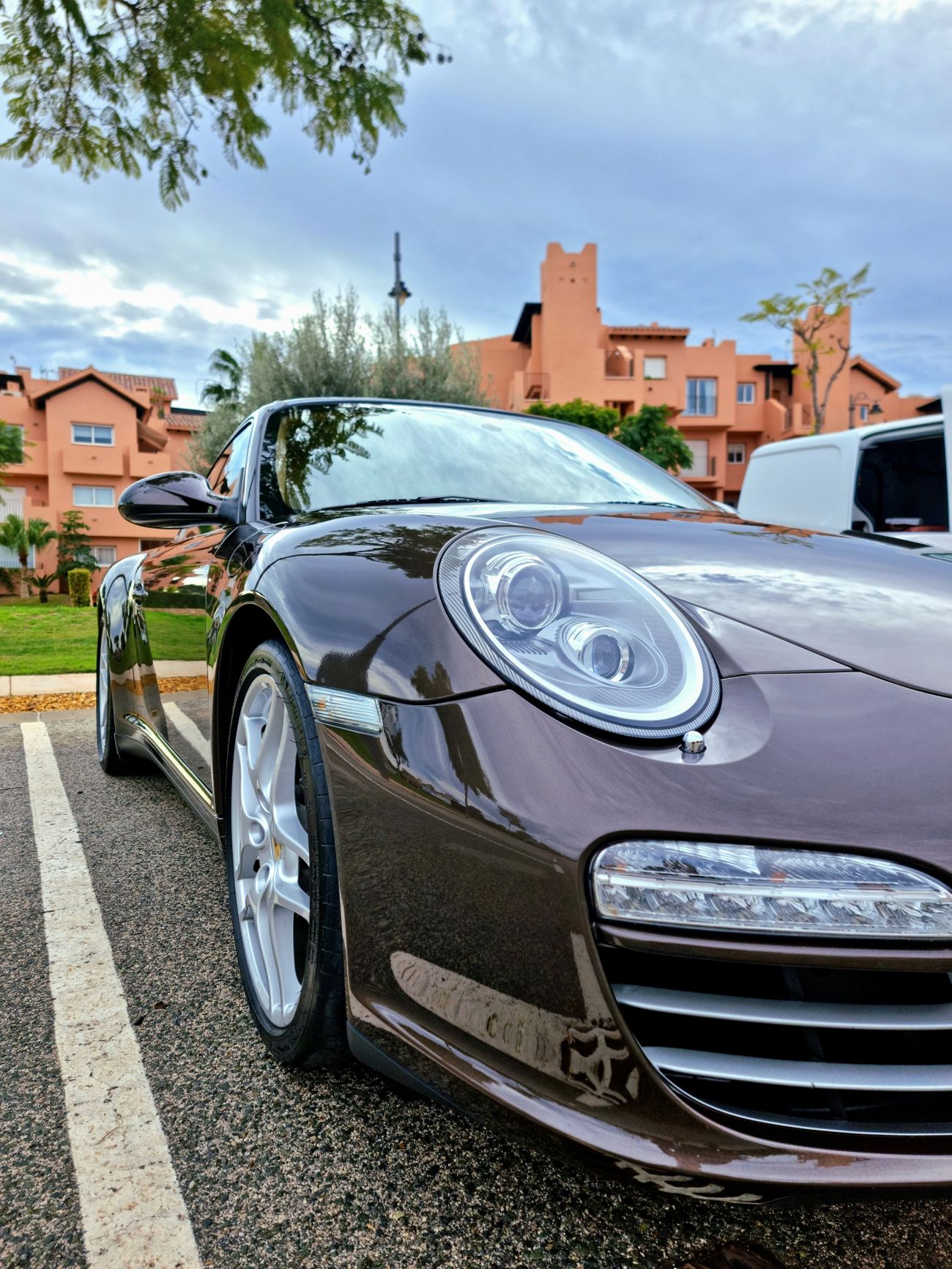 A brown Porsche 911 with deep reflections after a hand valet